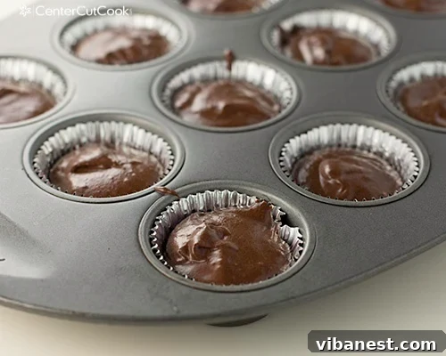 Chocolate Oreo Cupcakes in baking liners Freshly baked Chocolate Oreo cupcakes, some showing the Oreo peeking from the bottom.