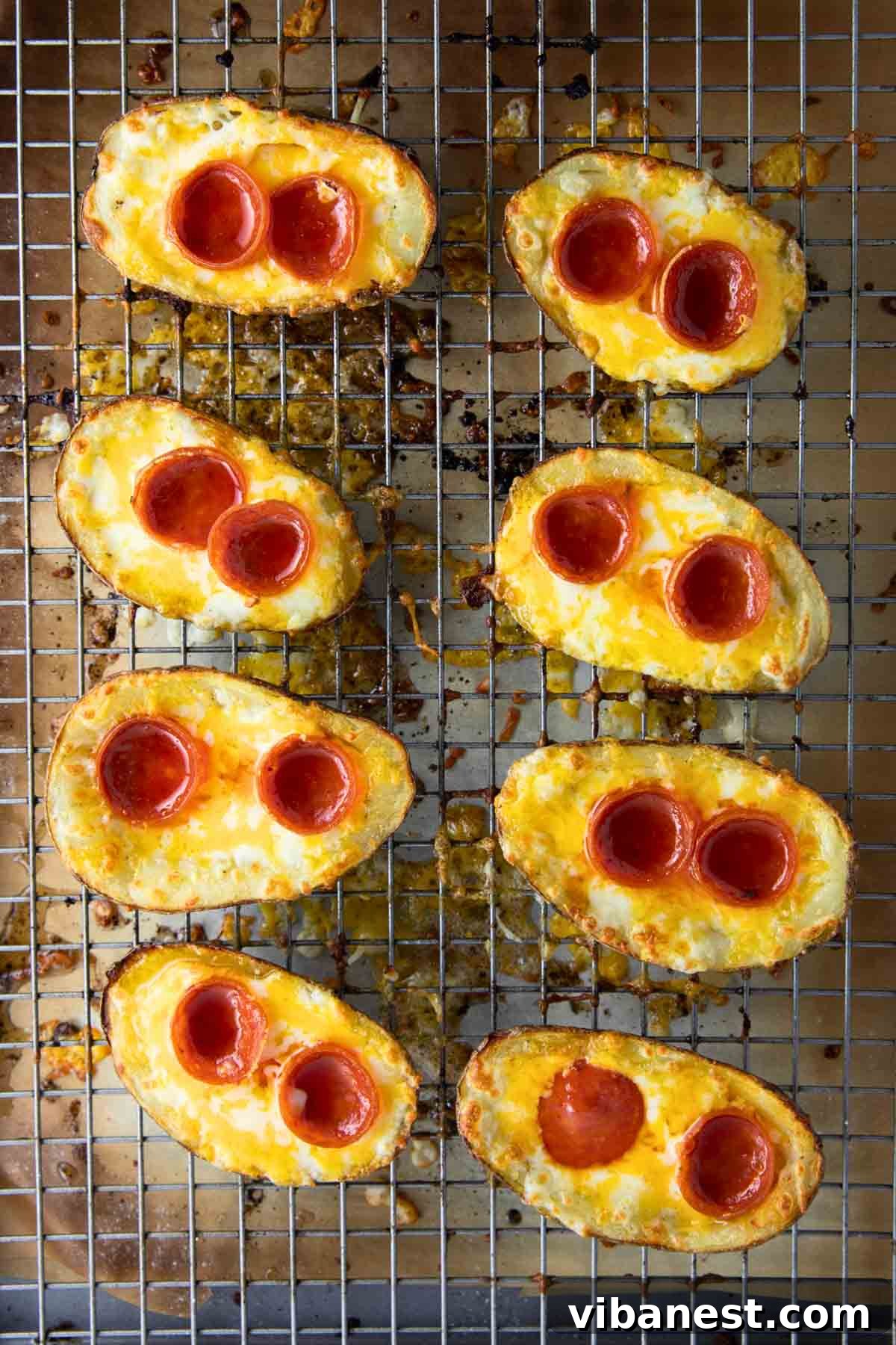 Cheesy Pizza Potato Bites 11 A tantalizing view of pizza potato skins sizzling on a baking tray inside an oven, the cheese perfectly melted and bubbling, indicating they are almost ready to be served.