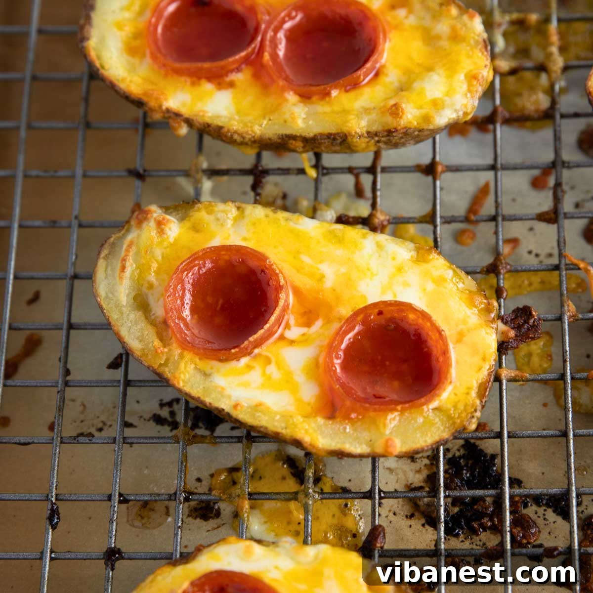 Cheesy Pizza Potato Bites 12 A meticulously arranged serving of gourmet pizza potato skins, garnished with fresh herbs, presented on a rustic wooden board, ready for an exquisite dining experience.