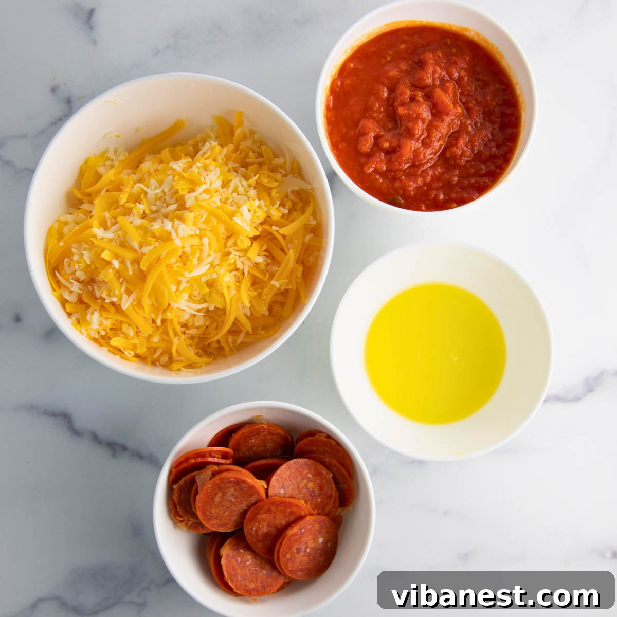 Cheesy Pizza Potato Bites 5 A perfectly arranged spread of fresh ingredients for pizza potato skins on a kitchen counter, including russet potatoes, mozzarella cheese, pepperoni, butter, and Italian seasoning.