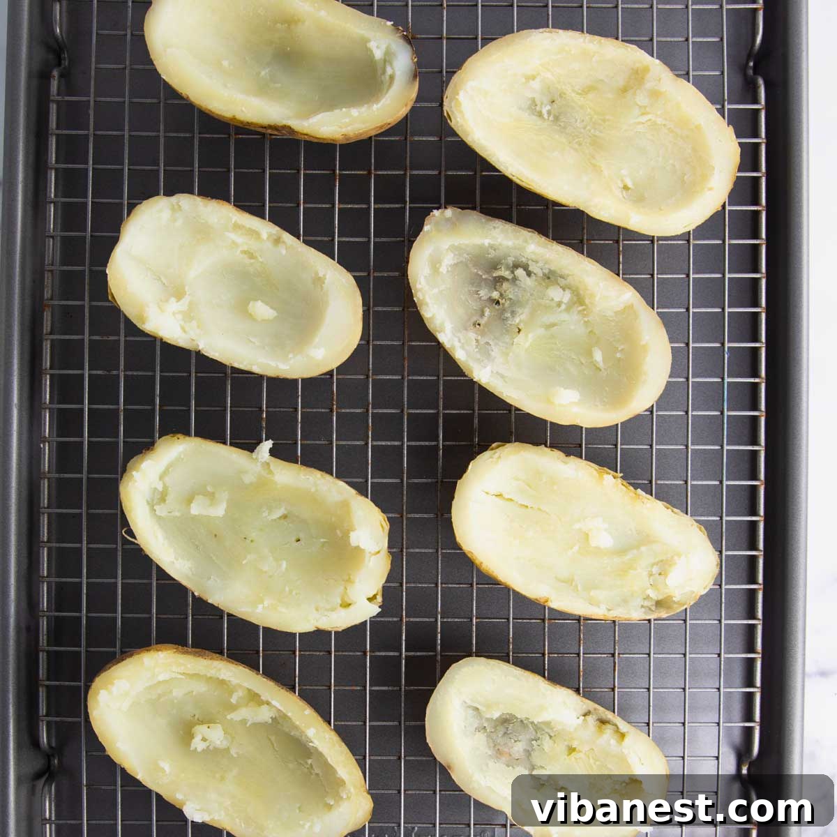 Cheesy Pizza Potato Bites 7 Prepared potato skins lined up on a baking sheet, brushed with melted butter and seasoned with salt and pepper, ready for the broiler to achieve a perfect crisp.