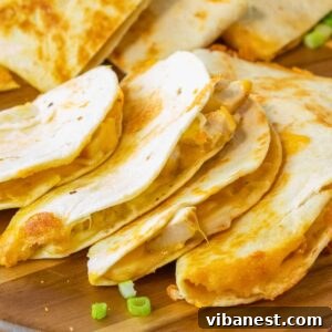 A perfectly cooked quesadilla, cut into triangles, with melted cheese visible inside, ready to be enjoyed.