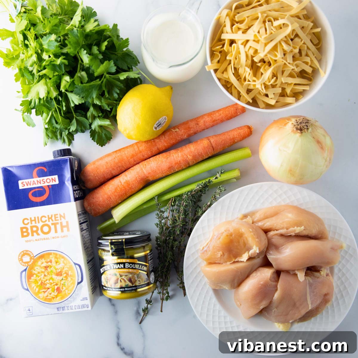 Comforting Creamy Chicken Noodle Soup 4 An overhead shot showcasing all the fresh, vibrant ingredients laid out for making creamy chicken noodle soup, ready for preparation.