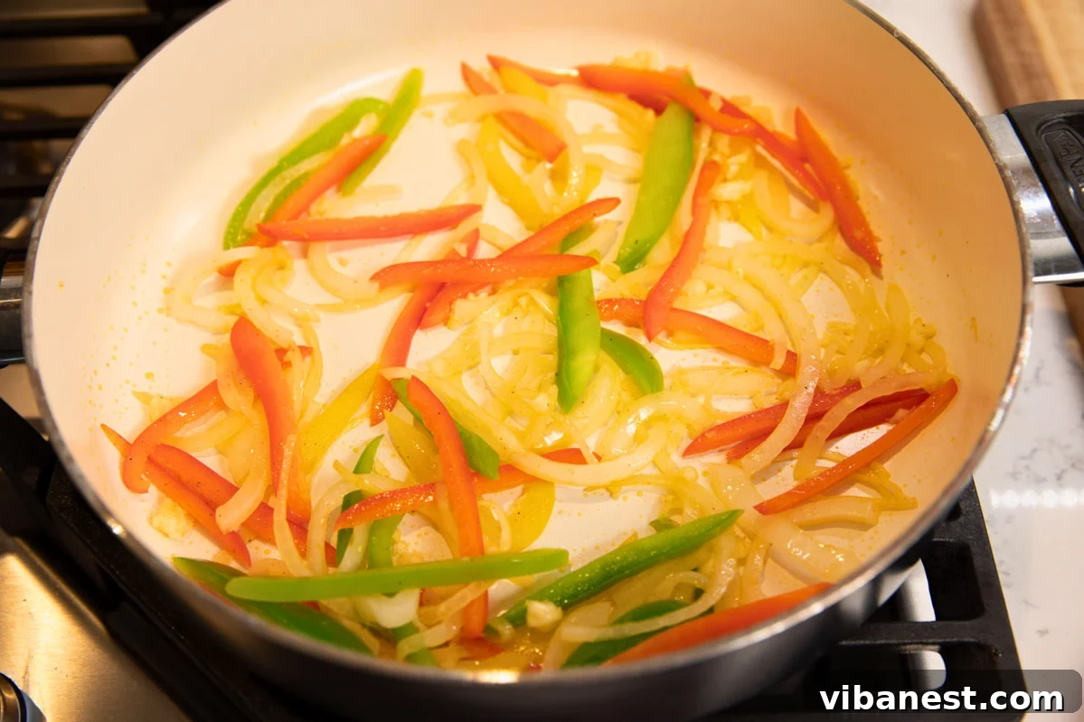 Sizzling Pepper Steak with Onions 4 Colorful green bell pepper, red bell pepper, and onion slices in a skillet