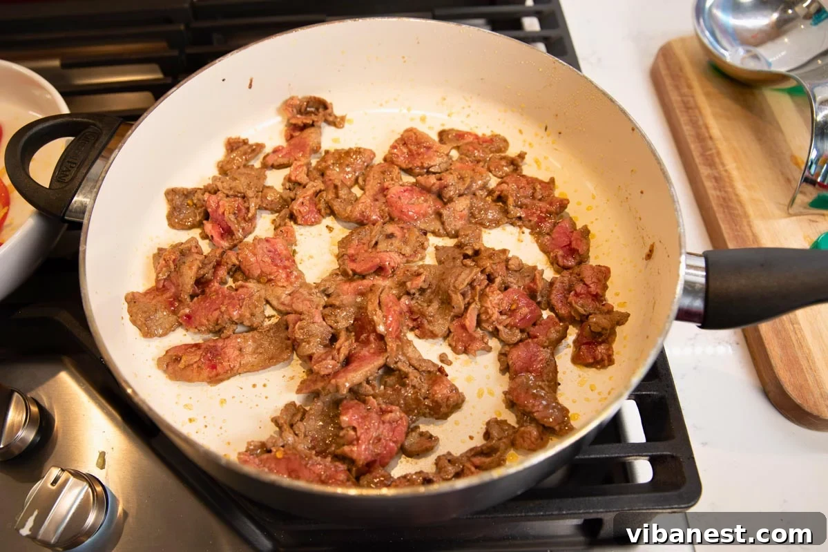 Sizzling Pepper Steak with Onions 5 Large skillet with flank steak stir-frying