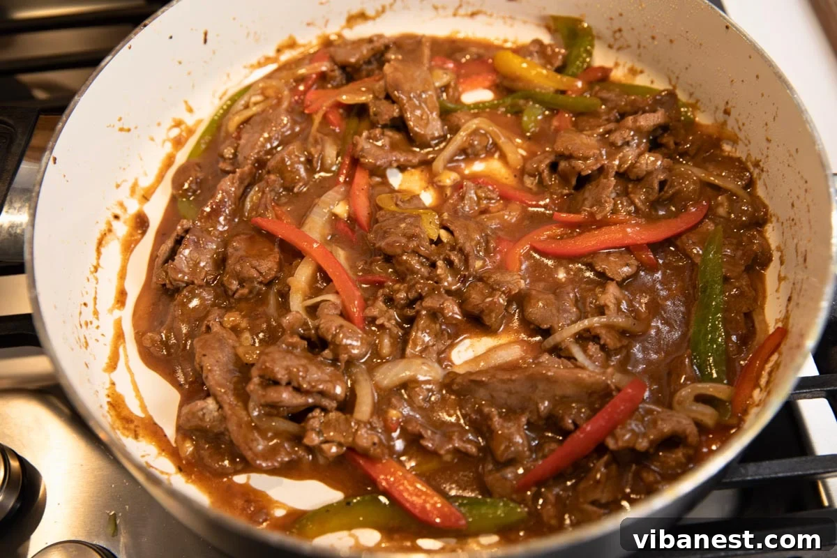 Sizzling Pepper Steak with Onions 6 Skillet filled with cooked pepper steak and onions in savory sauce