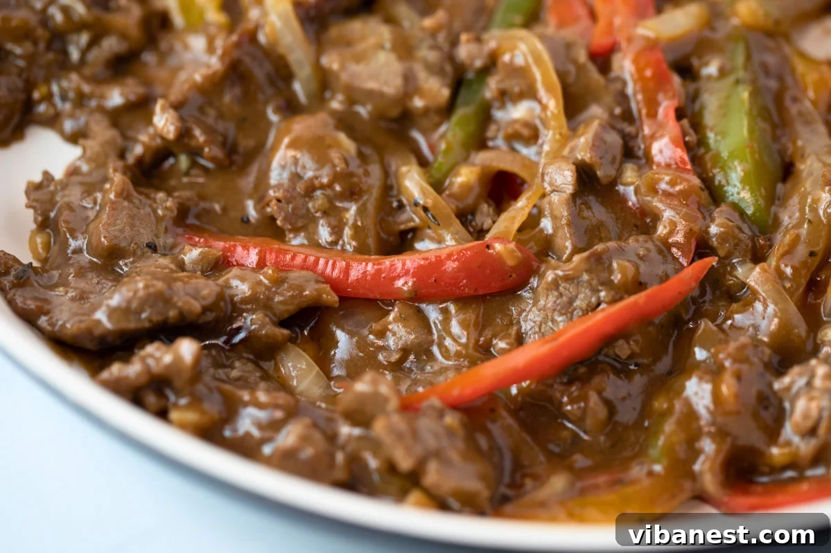 Sizzling Pepper Steak with Onions 9 Close-up of pan with pepper steak and onions simmering in the sauce