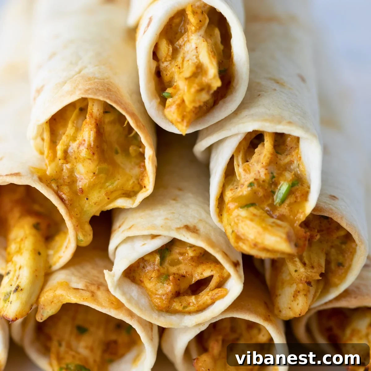 Crispy Air Fryer Chicken Taquitos 2 Golden-brown crispy air fryer chicken taquitos on a serving platter, ready to eat