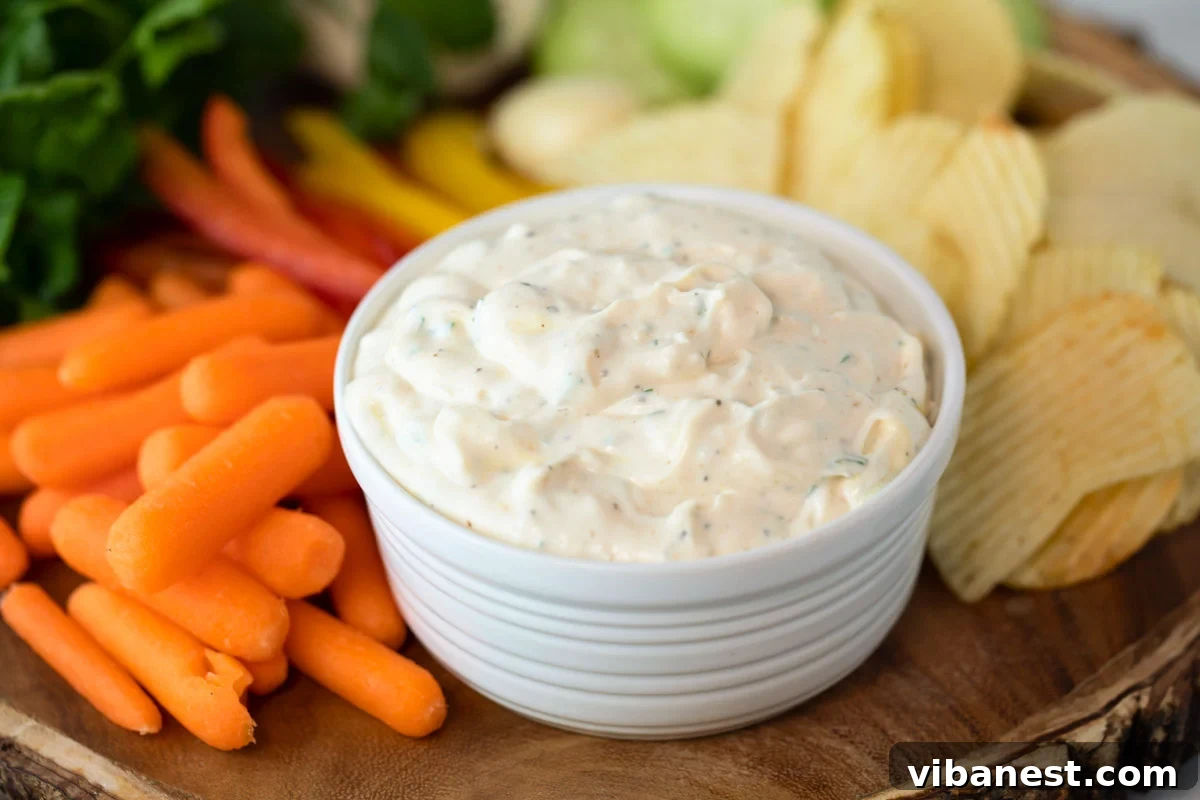 Velvet Garlic Delight 5 A beautifully arranged bowl of creamy garlic dip, artfully surrounded by a selection of fresh vegetables and crispy chips, illustrating a perfect serving display.