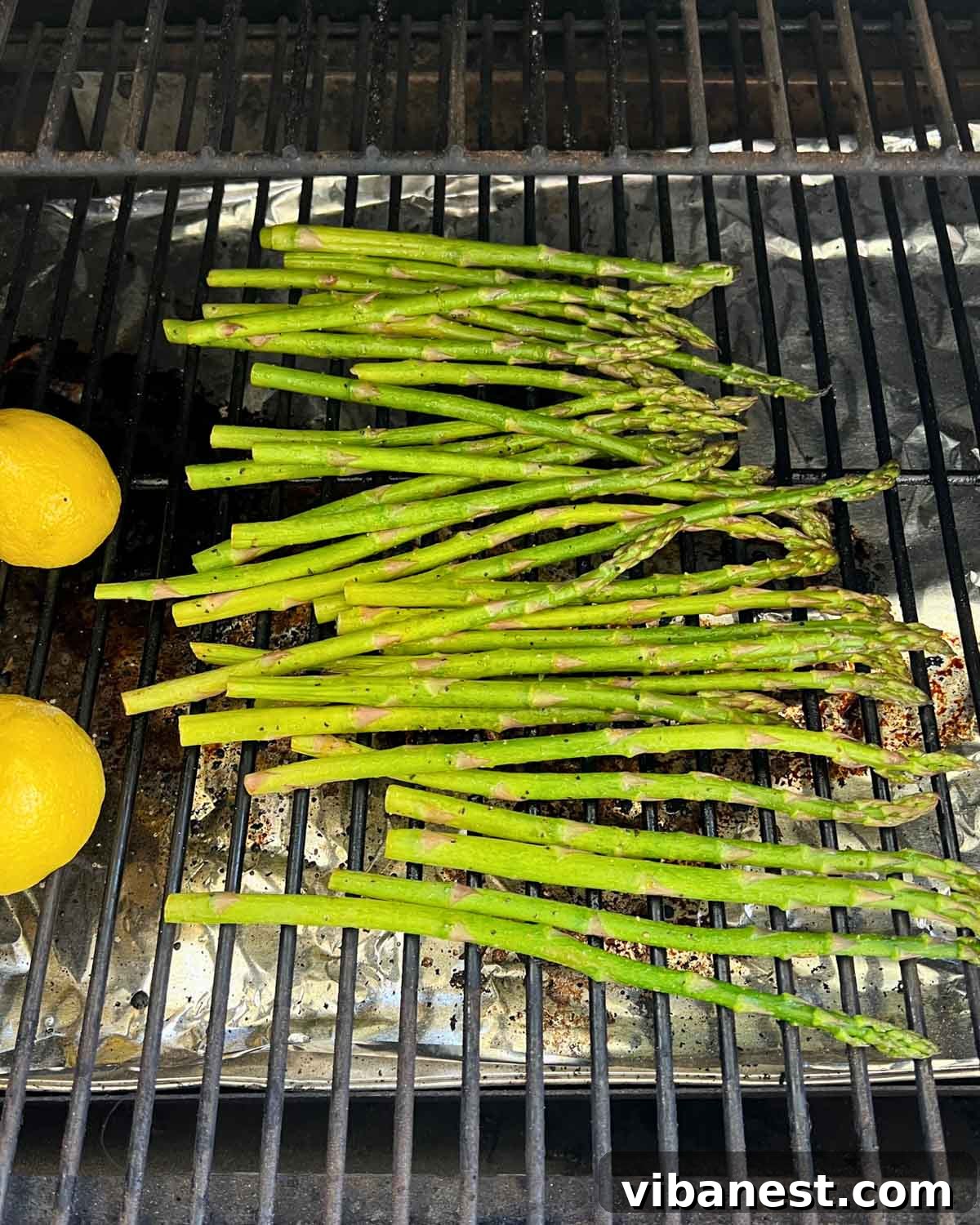 Effortless Grilled Asparagus 4 Fresh asparagus and sliced lemons cooking on a hot grill, showing perfect char marks.