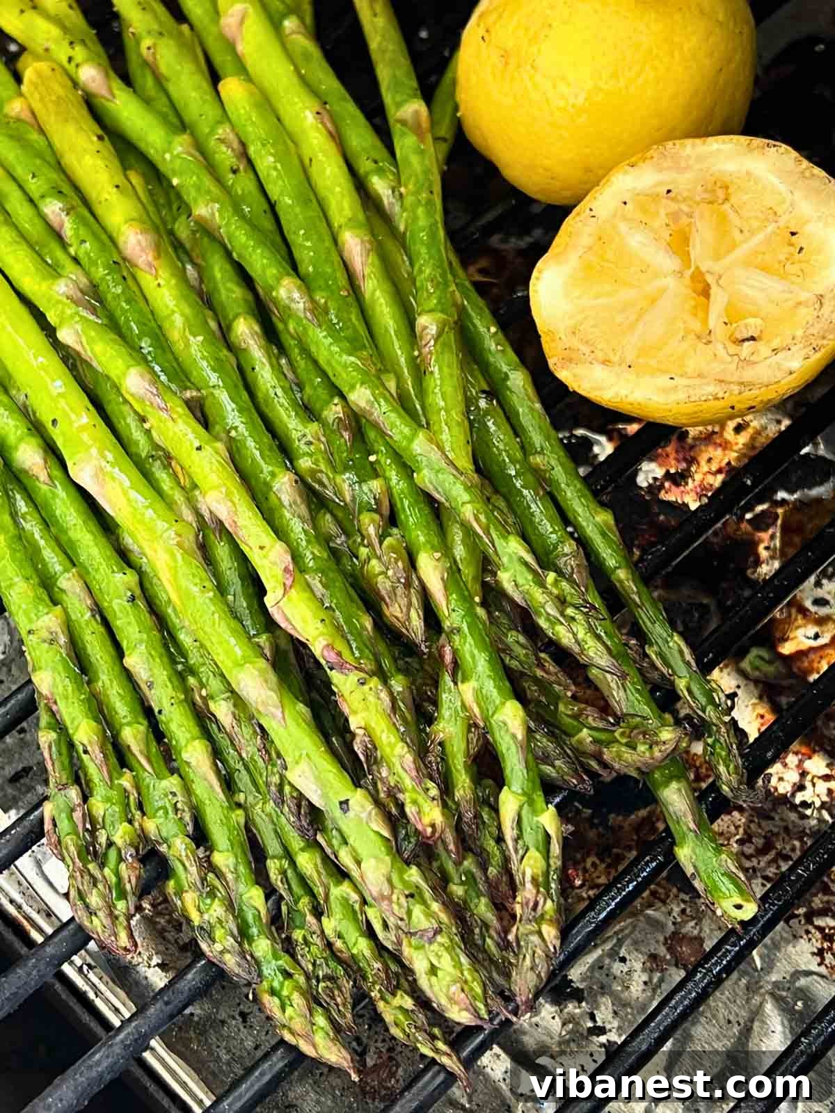 Effortless Grilled Asparagus 7 A vibrant platter of grilled asparagus, garnished with fresh lemon halves, showcasing a perfect spring side dish.