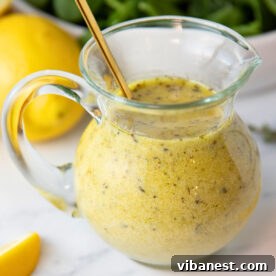 Smoky Grilled Asparagus Salad 7 Homemade lemon vinaigrette dressing in a clear jar, showing its bright yellow color.