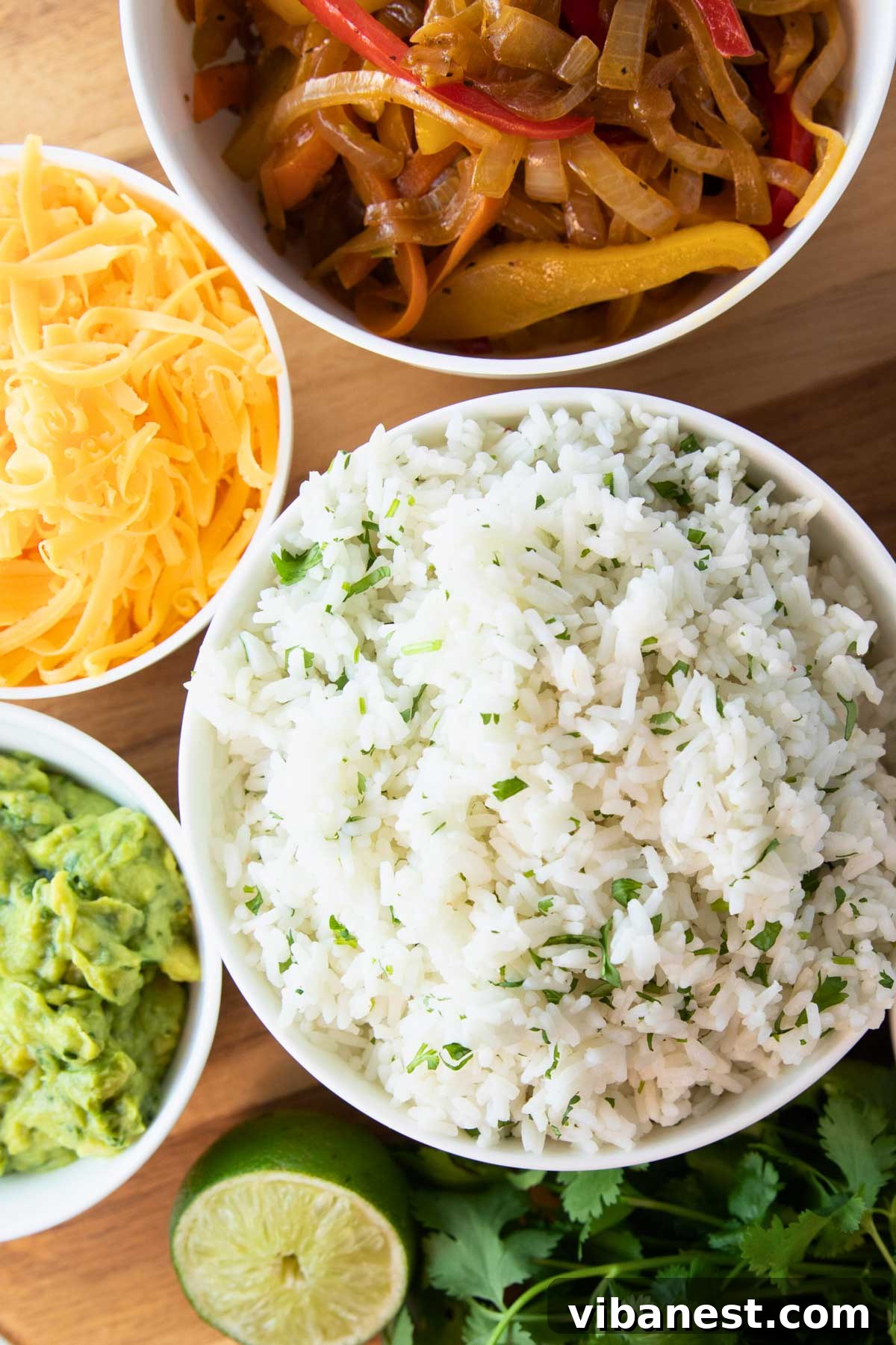 Zesty Instant Pot Cilantro Lime Rice 5 A hearty bowl of Instant Pot Cilantro Lime Rice served alongside other fajita toppings like grilled chicken, peppers, and onions.