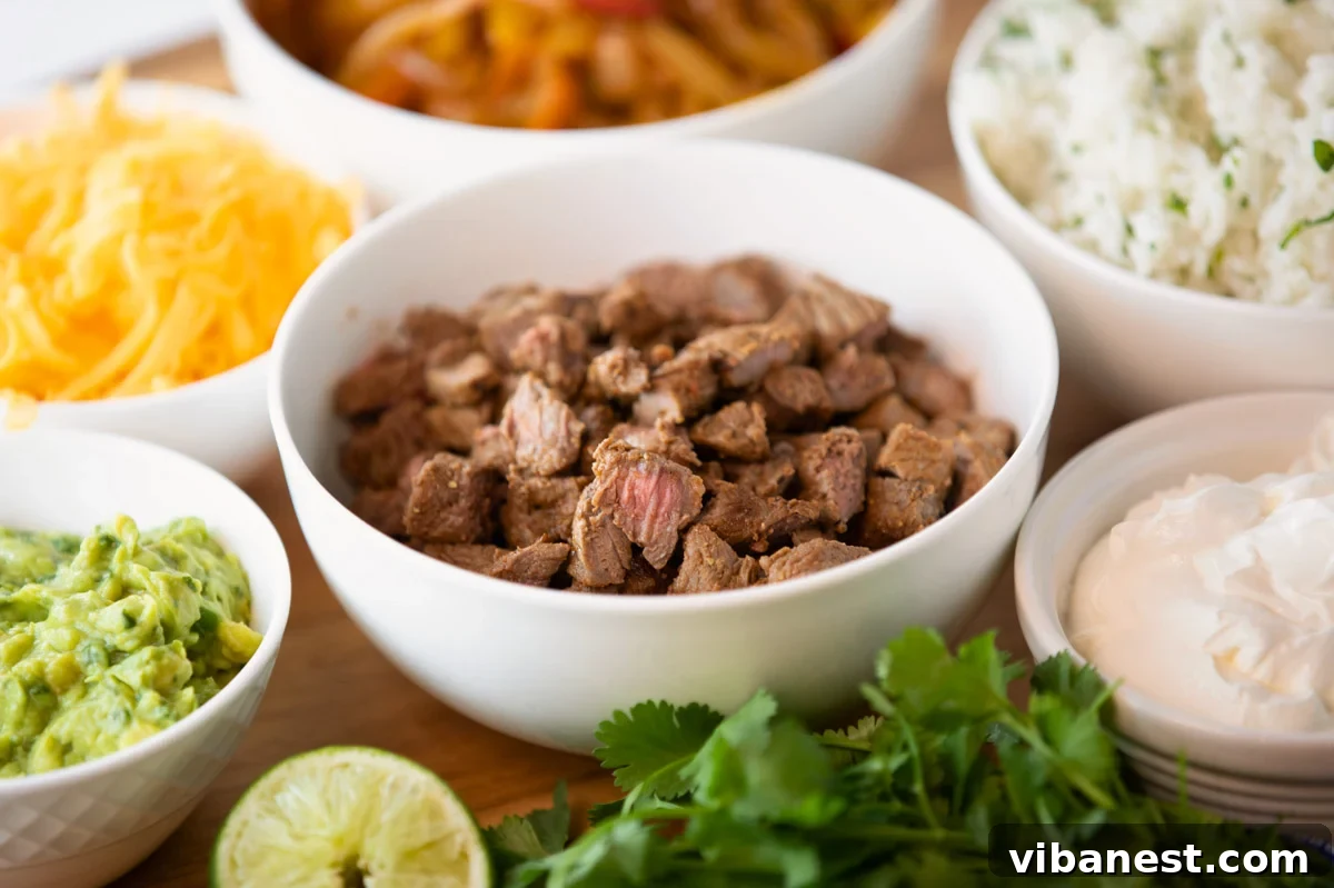 Air Fryer Fajita Burrito Steak 8 An inviting spread of bowls containing all the delicious components for air fryer steak fajitas, including steak, toppings, and tortillas.