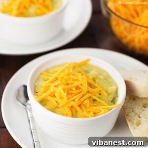 A comforting bowl of homemade Broccoli Cheese Soup, garnished with extra shredded cheddar cheese and served with a side of crusty bread.
