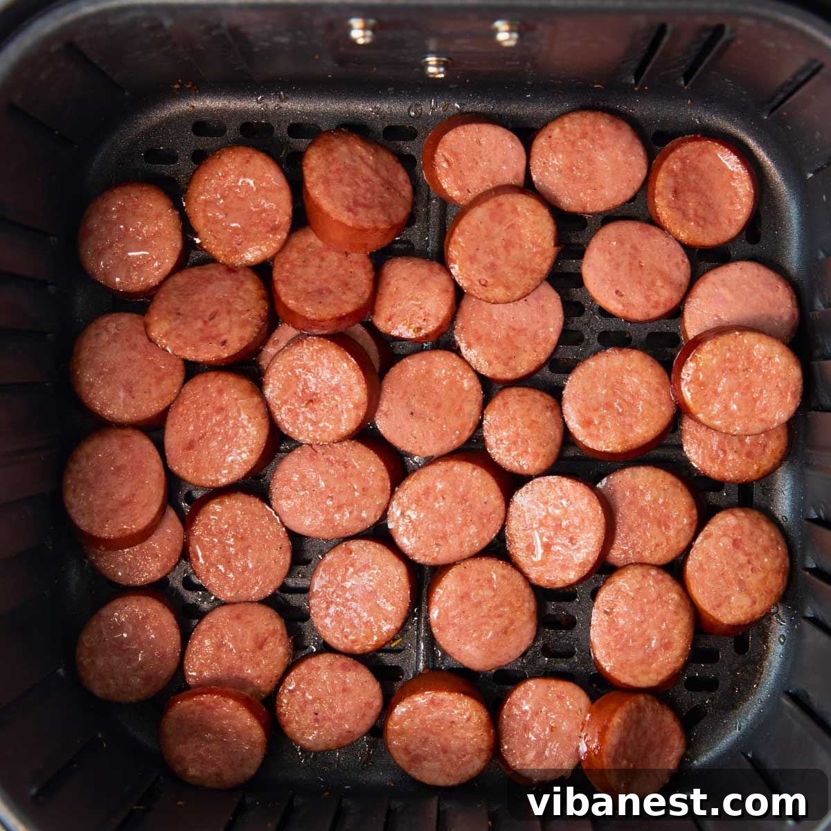 Perfect Air Fryer Kielbasa 3 overhead of air fryer basket of sliced kielbasa sausage