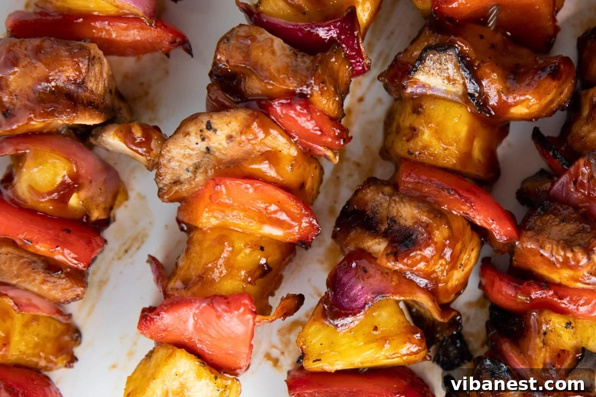 Char-Grilled BBQ Chicken Skewers 12 Platter of delicious Grilled BBQ Chicken Kabobs ready to be served, alongside a bowl of BBQ sauce for dipping