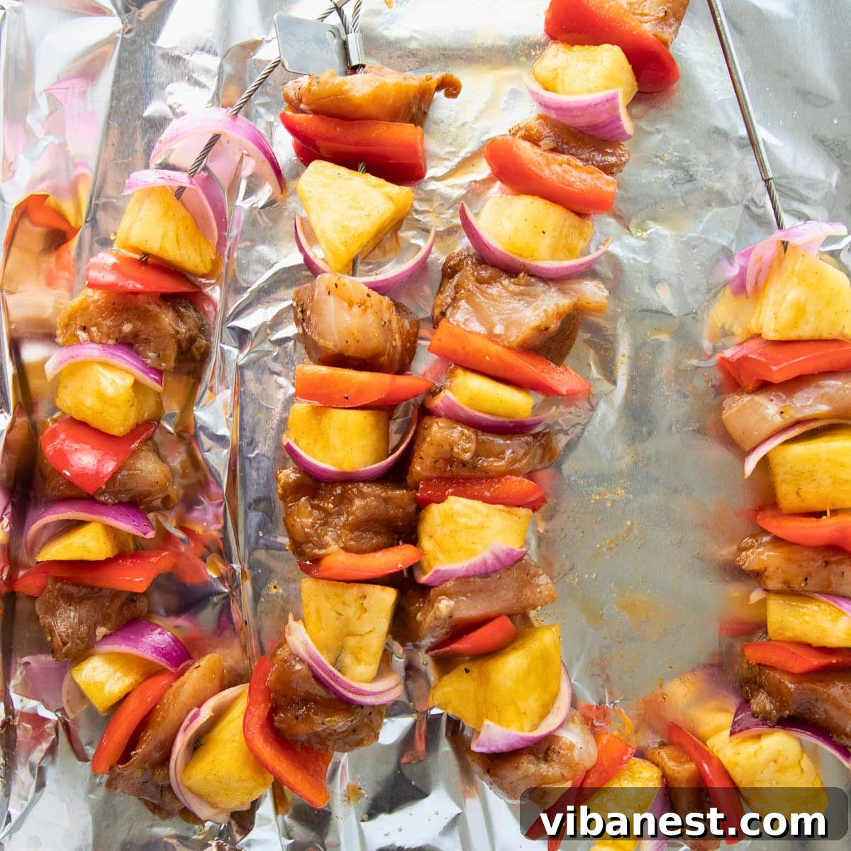 Char-Grilled BBQ Chicken Skewers 6 Assembled kabobs with alternating chicken, pineapple, peppers, and onions on skewers, ready for grilling
