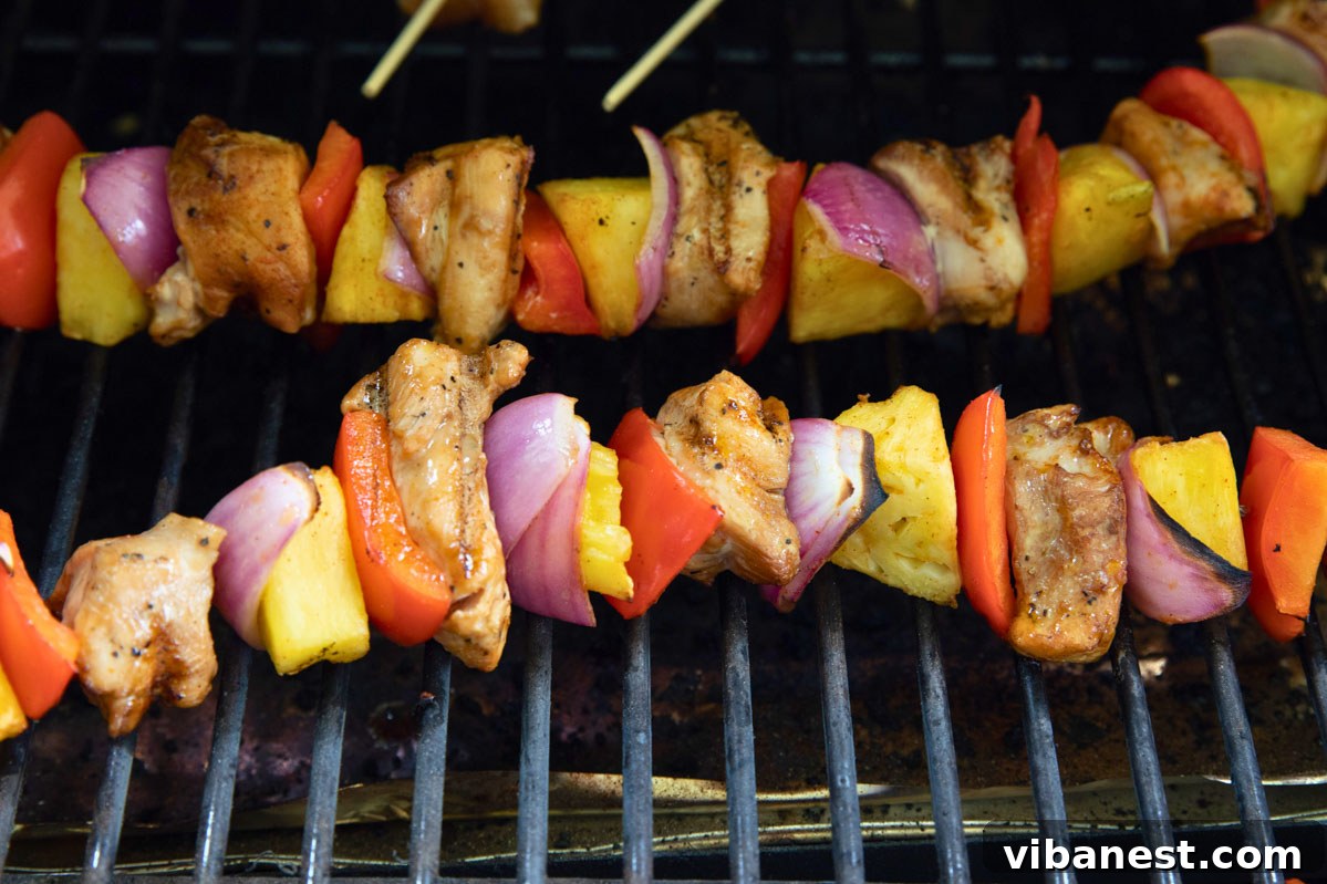 Char-Grilled BBQ Chicken Skewers 7 Grilled BBQ chicken skewers sizzling on a hot grill with visible char marks