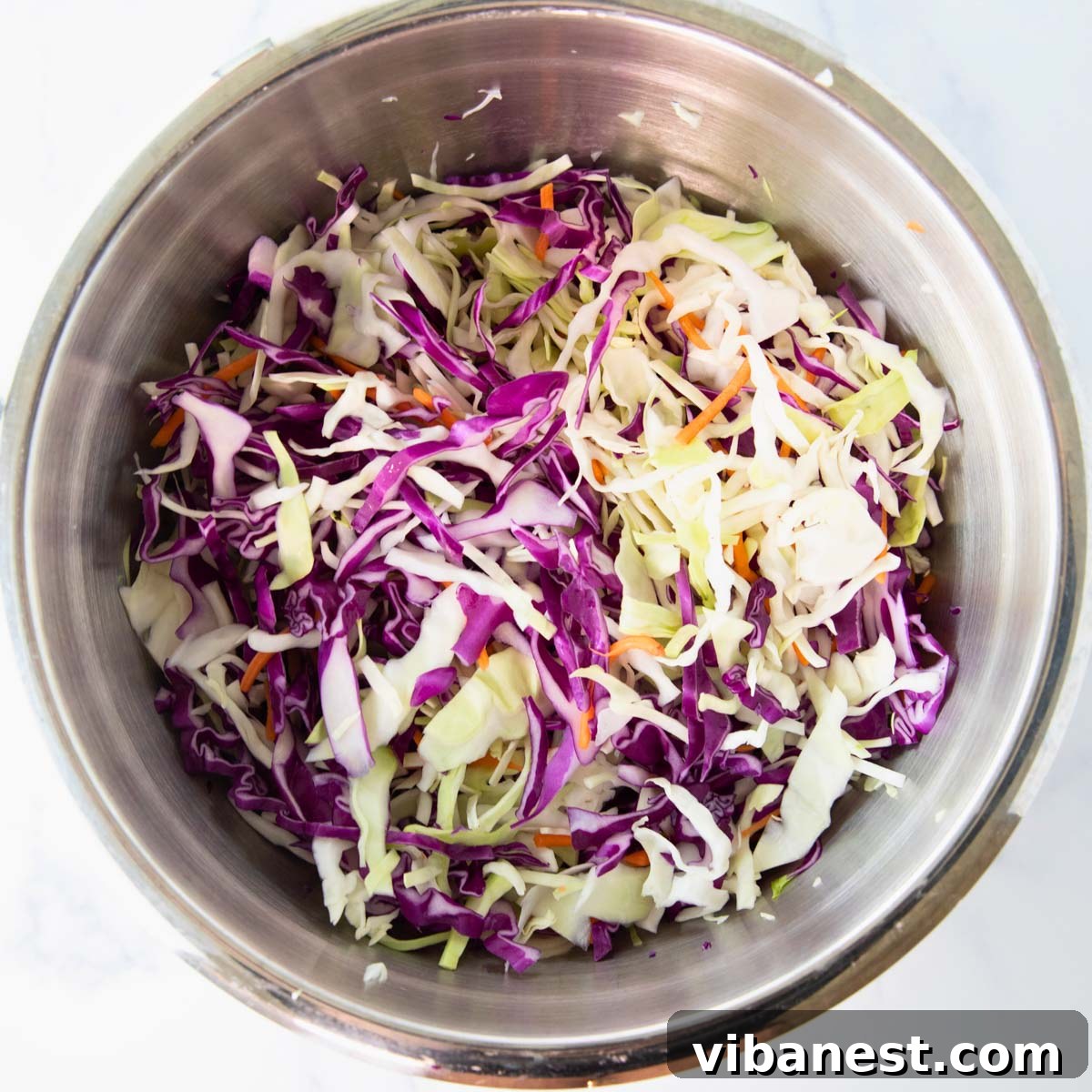 Bright Apple Cider Vinegar Slaw 6 Mixing the cabbage, carrots, and warm dressing in a bowl.