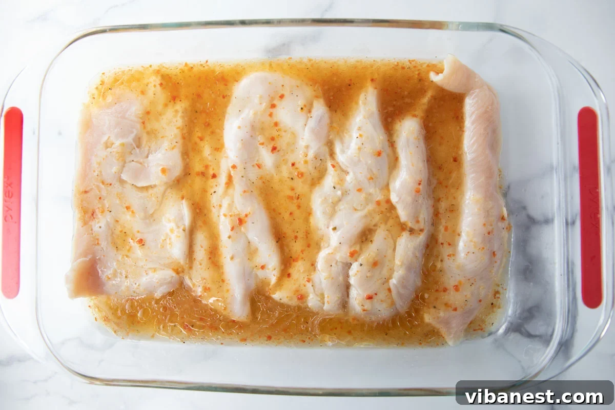 Effortlessly Delicious Thin Chicken Breasts 3 Thin sliced chicken breasts marinating in a flavorful Italian dressing in a baking dish