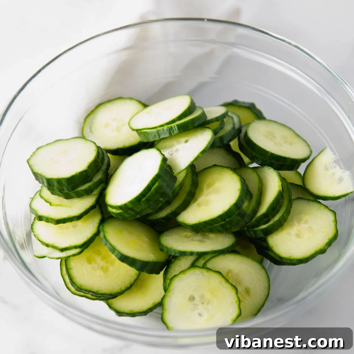 TikToks Viral Cucumber Salad Duet 4 Neatly sliced cucumber rounds, uniformly thin and crisp, piled high and ready to be turned into a delicious salad.