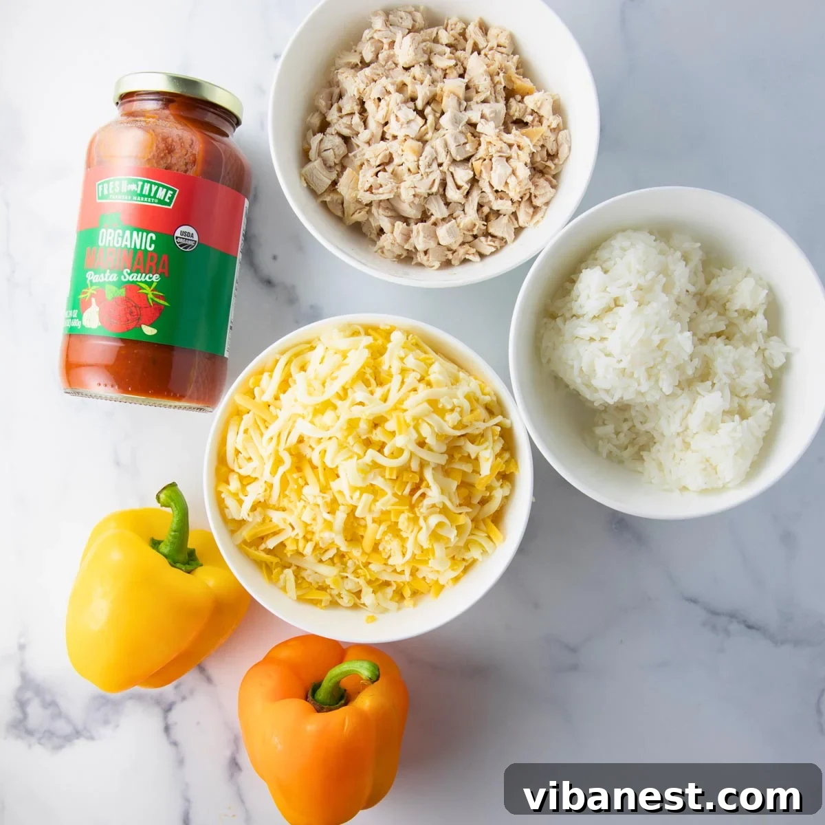Hearty Chicken Stuffed Bell Peppers 4 A selection of fresh ingredients including bell peppers, chicken, rice, cheese, and seasonings, laid out for making stuffed peppers.