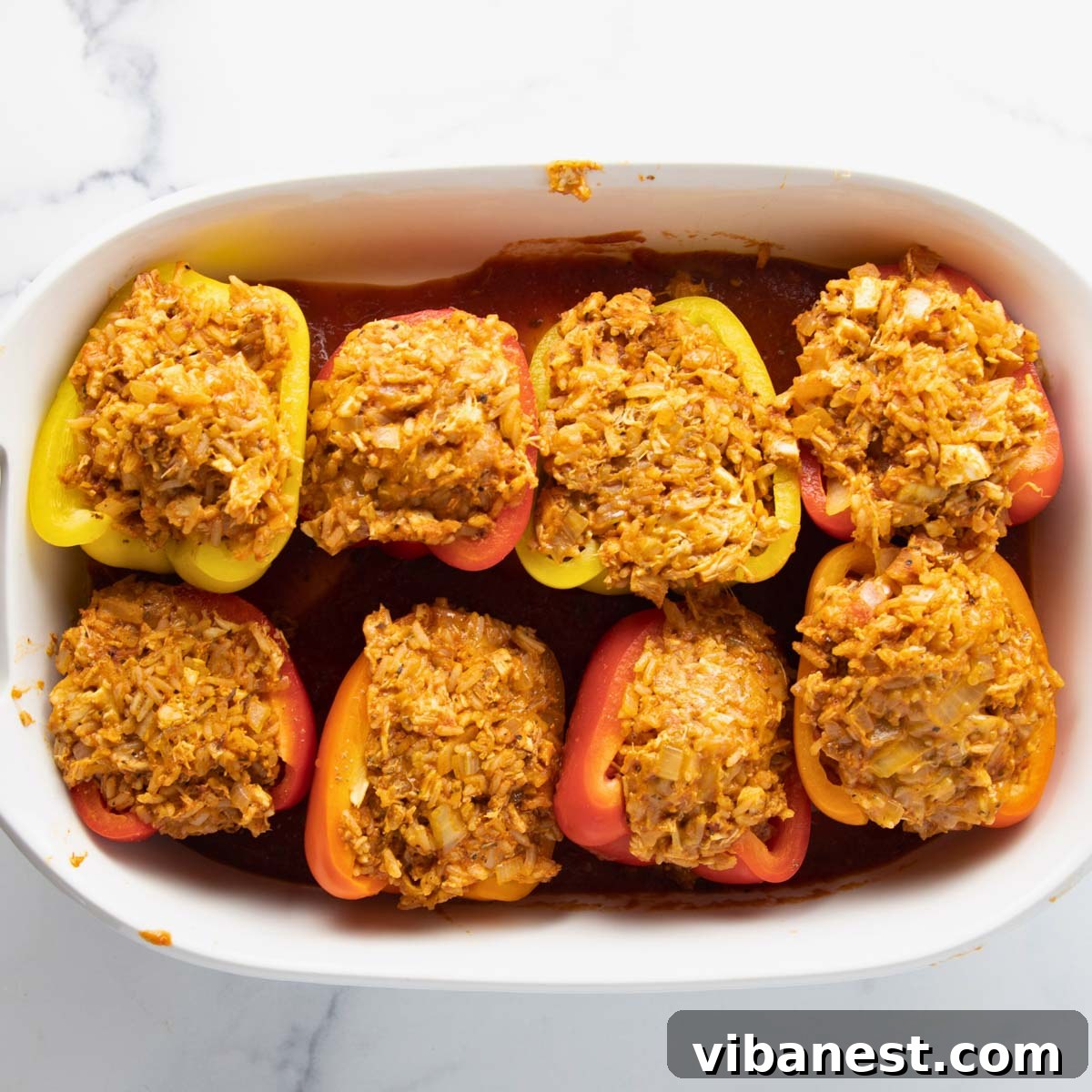 Hearty Chicken Stuffed Bell Peppers 7 Bell peppers stuffed with chicken and rice mixture, then topped generously with shredded cheese, ready for baking.