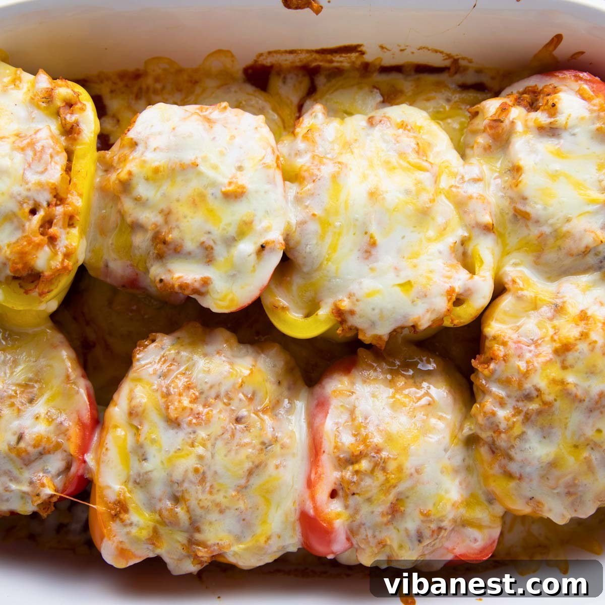 Hearty Chicken Stuffed Bell Peppers 9 Chicken stuffed bell peppers baking in a casserole dish, covered with foil for the initial cooking phase.