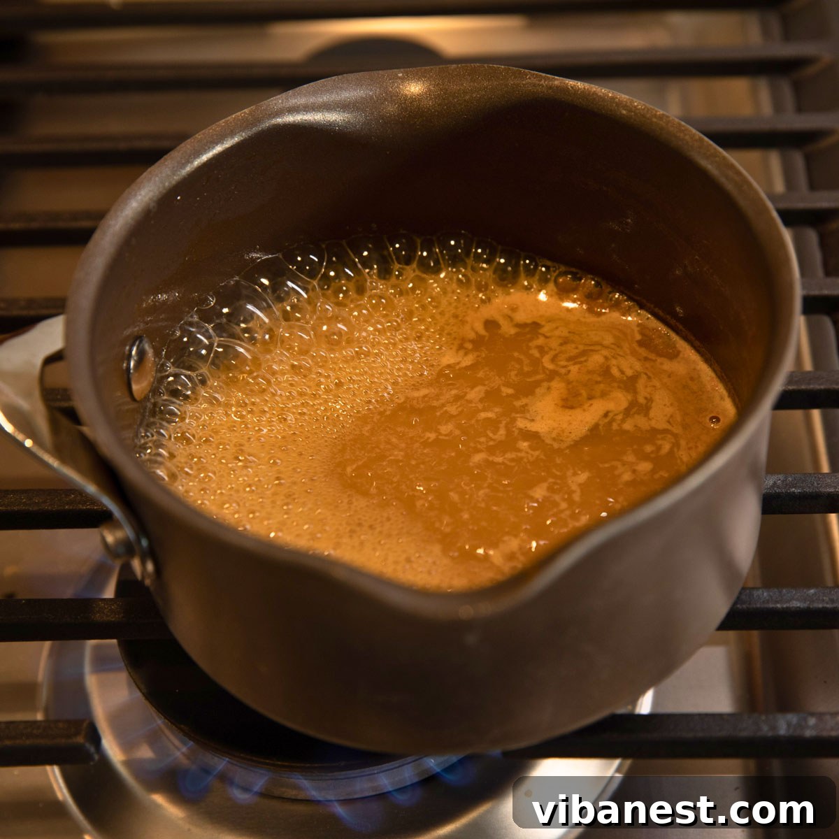 Crisp Apple Vinaigrette 5 Apple cider boiling in a saucepan, reducing to concentrate its flavor for the vinaigrette.