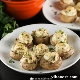 A plate of perfectly baked Stuffed Mushrooms, filled with a creamy, cheesy mixture