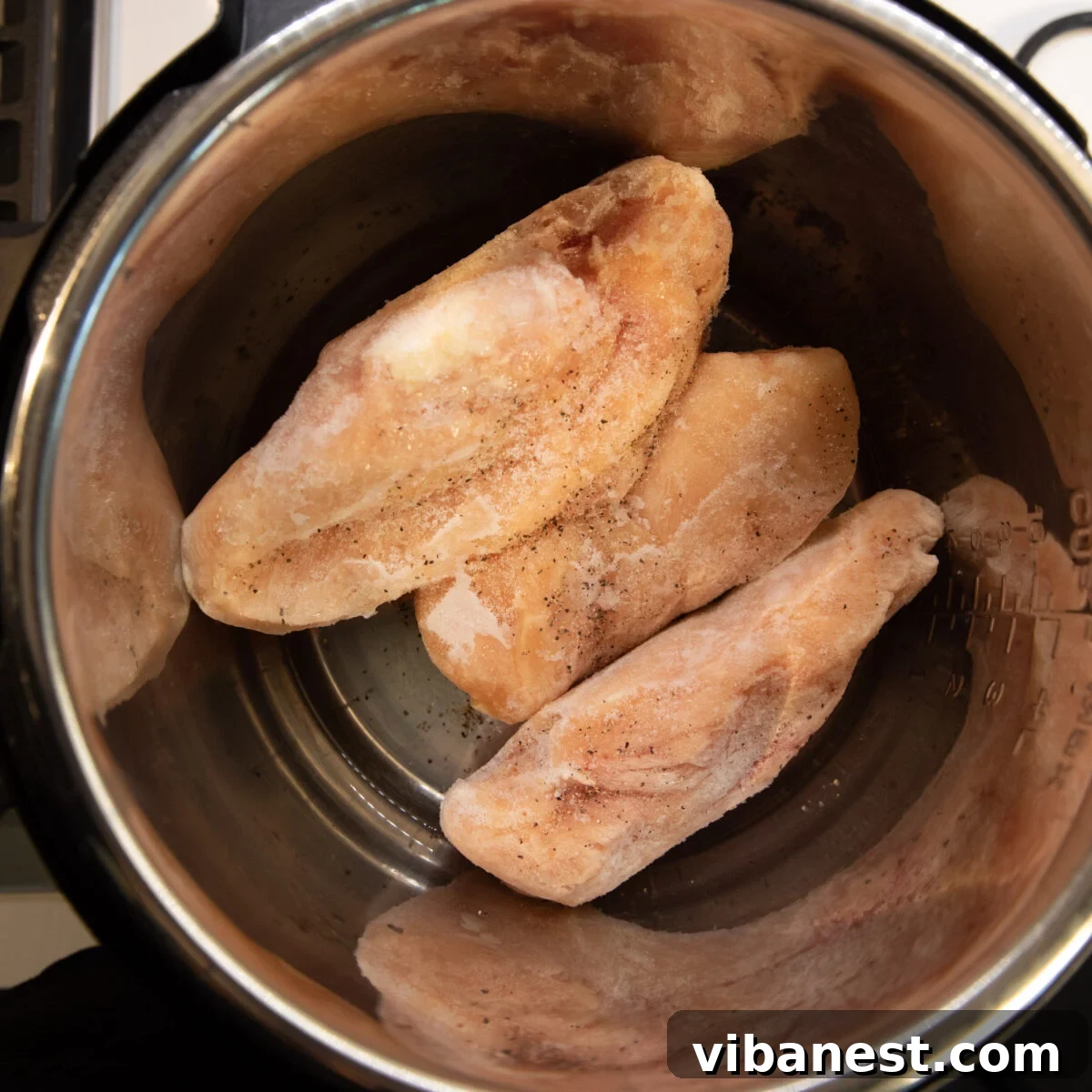 No Thaw, No Fuss Instant Pot Chicken Breasts 6 Frozen chicken breasts, seasoned and arranged in a single layer inside the Instant Pot, before cooking.