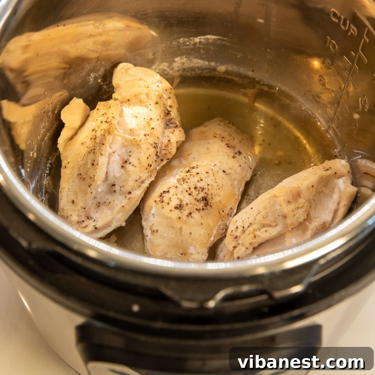 No Thaw, No Fuss Instant Pot Chicken Breasts 7 Freshly cooked, steaming chicken breasts inside the Instant Pot, perfectly tender and ready to be shredded or diced.