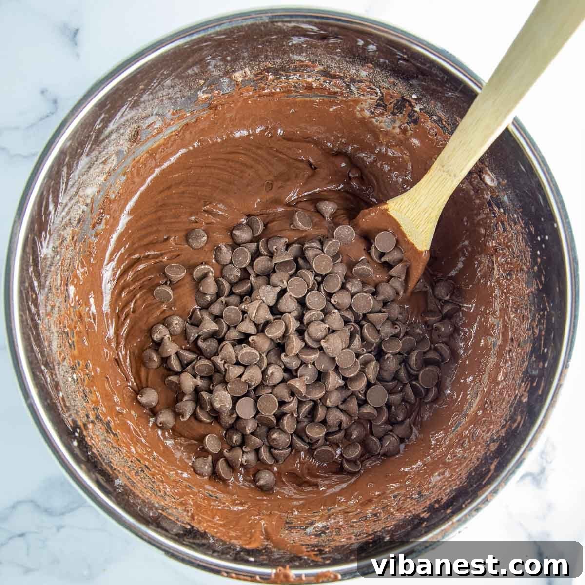 Decadent Double Chocolate Bundt Cake 10 Rich chocolate cake batter being mixed to a smooth, consistent texture with an electric mixer.