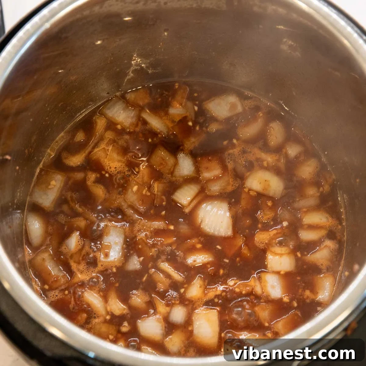 Instant Pot Irish Comfort Stew 10 Adding broth to the Instant Pot with the beef, vegetables, and Guinness.