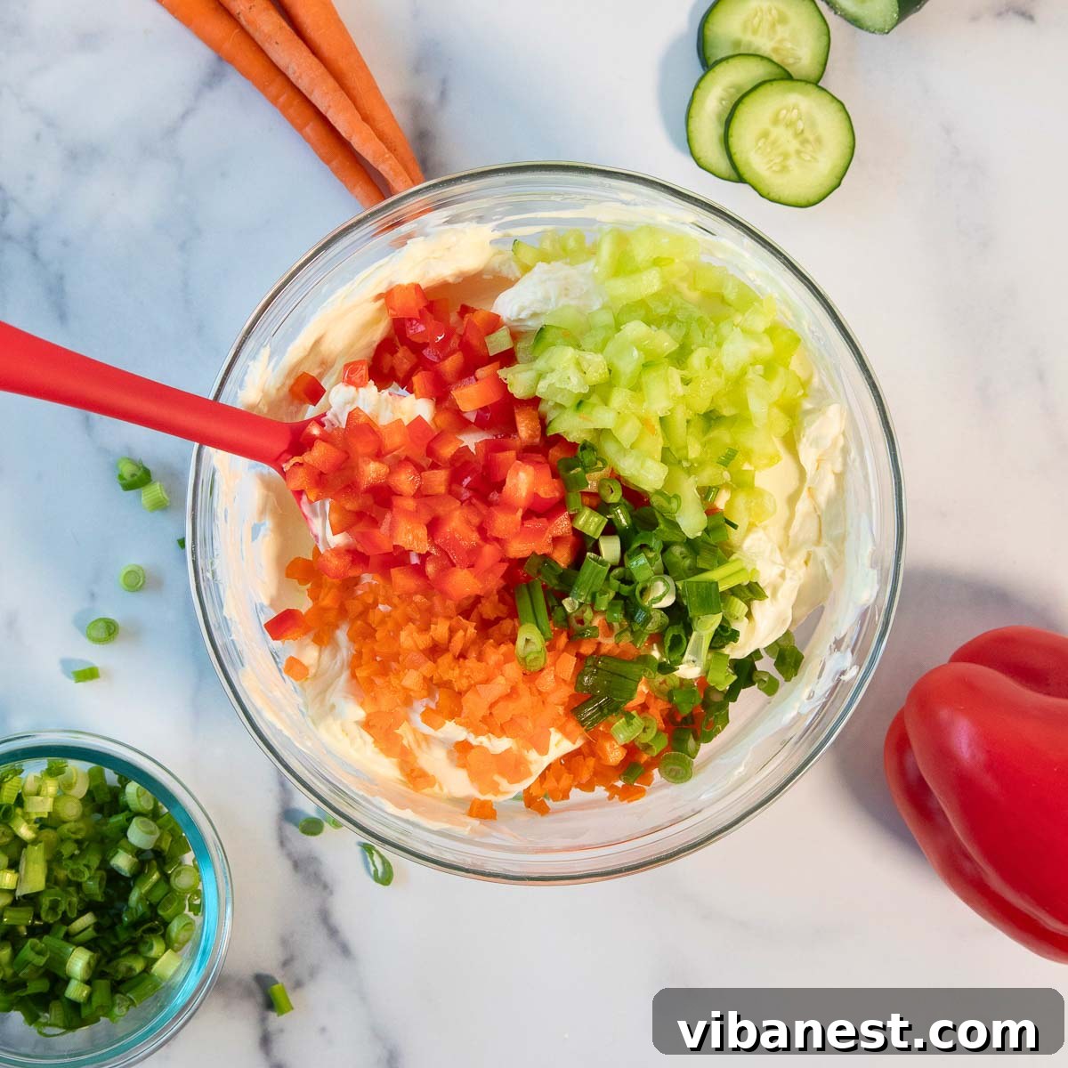 Garden Fresh Cream Cheese Veggie Spread 5 A bowl of cream cheese being mixed with a spoon.