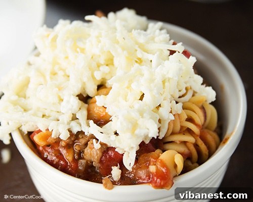 lasagna soup 6.jpg A bowl of lasagna soup with a generous layer of mixed cheese topping spread over it, before broiling.