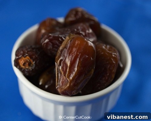 A close-up view of whole Medjool dates, highlighting their natural texture and rich color.