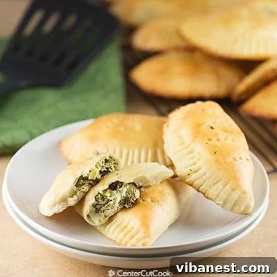 Two freshly baked Creamy Artichoke Spinach Pockets displayed on a plate, ready to be served