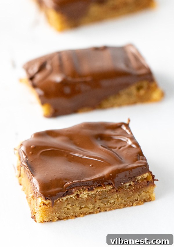 Stacked blondie bars with melted chocolate, showing the chewy texture