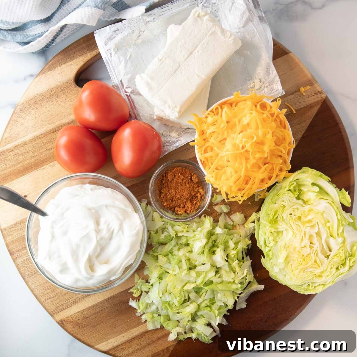 Ultimate Taco Party Dip 4 Collection of key ingredients for an easy taco dip, including cream cheese, sour cream, and a packet of taco seasoning, ready for mixing.