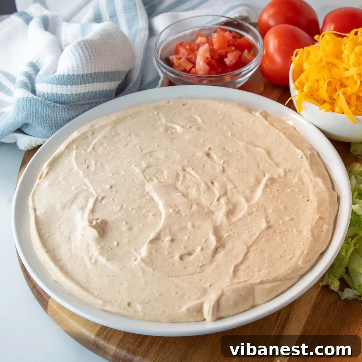 Ultimate Taco Party Dip 5 The creamy base for taco dip being prepared, showing a blend of cream cheese, sour cream, and taco seasoning in a bowl.