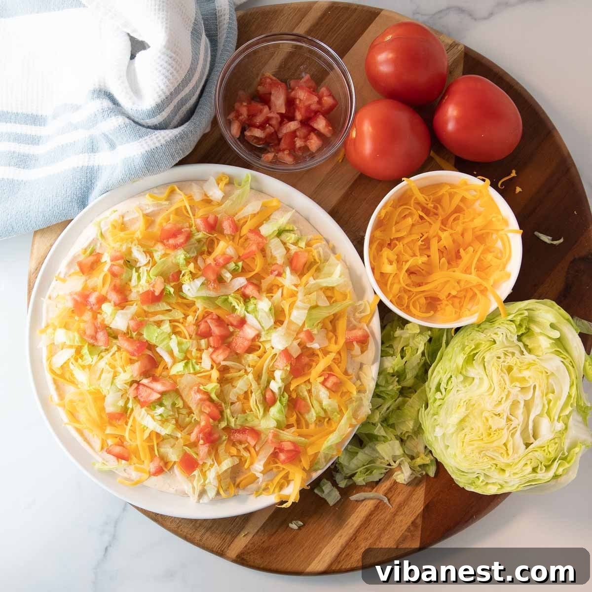 Ultimate Taco Party Dip 6 Taco dip assembled with its creamy base and first layer of cheese, ready for additional toppings.