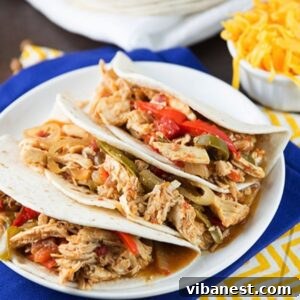 Effortless Slow Cooker Chicken Fajitas 2 Easy Slow Cooker Chicken Fajitas - A platter of cooked chicken, bell peppers, and onions ready to be served in tortillas.