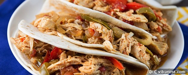 Slow Cooker Chicken Fajitas - Ready to Serve Close-up of a serving of slow cooker chicken fajitas with chicken, peppers, onions, and sauce, ready for tortillas.