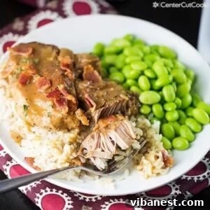 Slow Cooker's Dreamy Pork Chops 2 Plate of slow cooker smothered pork chops over rice with a side of green vegetable