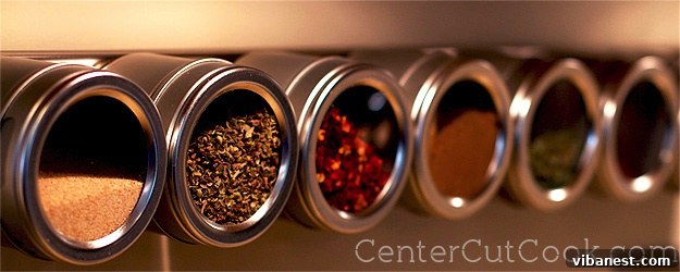 Collection of colorful spices in various containers, emphasizing culinary ingredients.