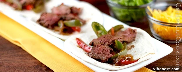 Delicious steak and chicken fajitas with vibrant grilled peppers and onions, ready to serve