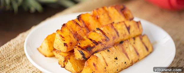 grilled pineapple.jpg Stacked grilled pineapple spears on a white plate, garnished with a sprig of mint