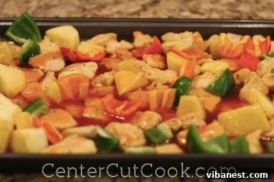 sschicken5.jpg Green bell peppers and pineapple chunks added to chicken in baking dish.